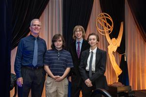 Davey_Shannon_Daly_Hancock stand on Emmy stage in front of statue